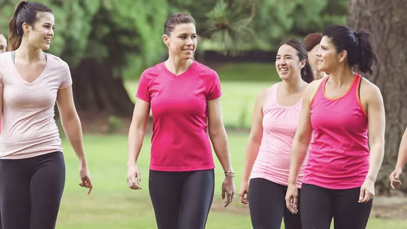 Group of women walking together outdoors in pink shirts