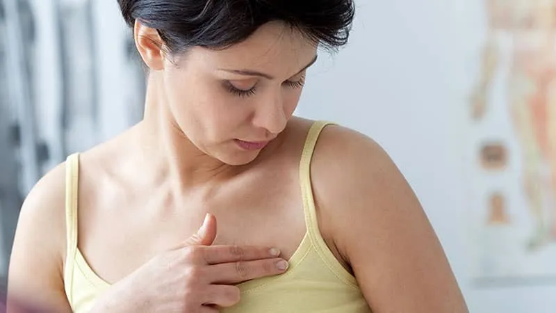 Woman checking her breast for lumps